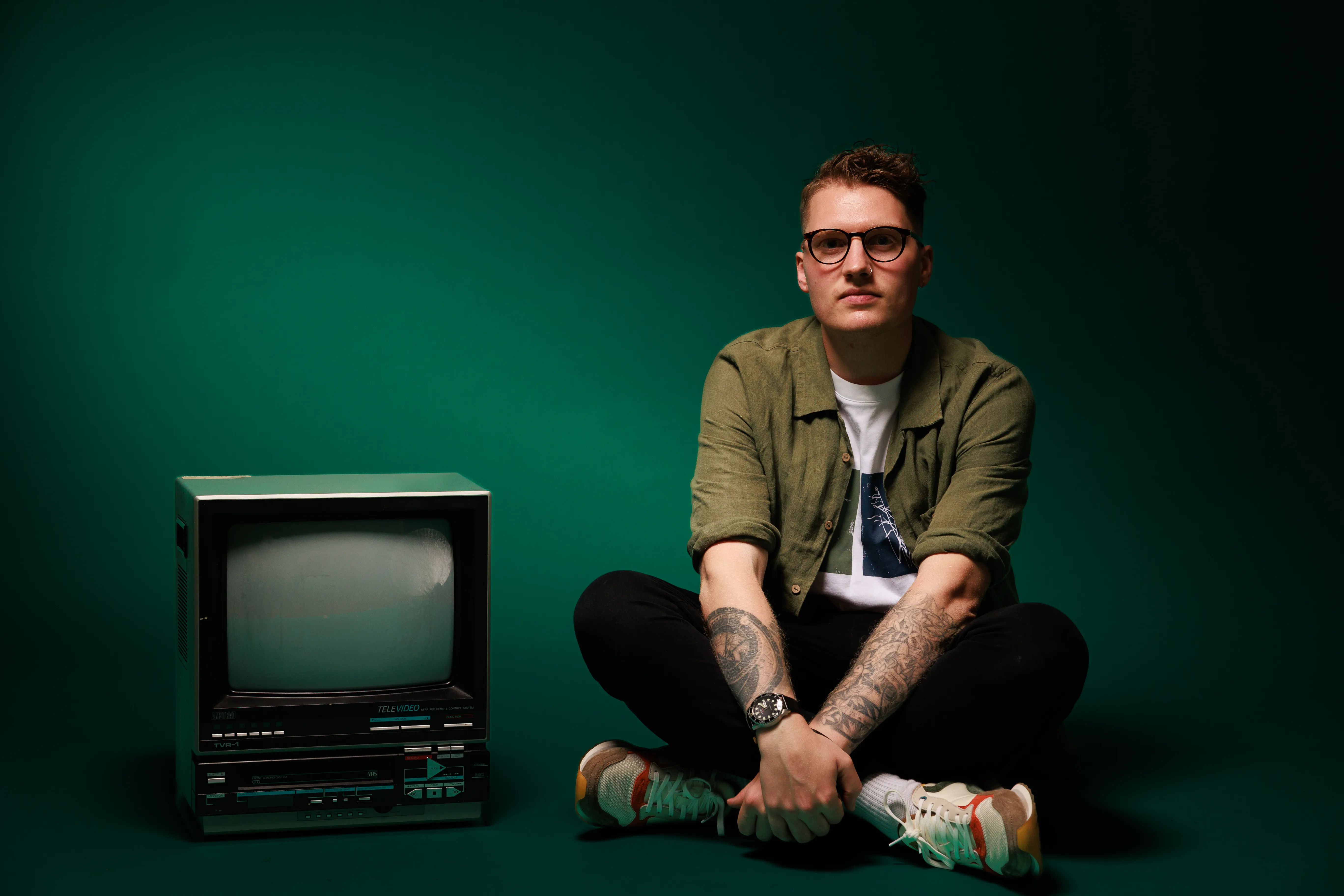 JB resting his arm on a vintage television